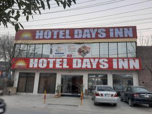 Hotel Day In Lahore في لاهور: نزل أيام الفندق مع سيارات متوقفة أمامه