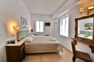 a bedroom with a bed and a mirror at Mistral Hotel in Hydra