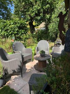 um grupo de cadeiras e uma mesa num jardim em Aggarthi Bed and Breakfast em Bayeux