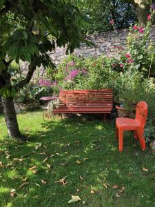a bench and a chair in a garden at Aggarthi Bed and Breakfast in Bayeux