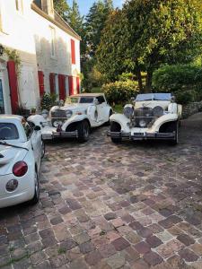 Tre macchine bianche parcheggiate di fronte a una casa di Aggarthi Bed and Breakfast a Bayeux