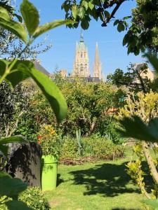 uma vista para uma catedral a partir de um jardim com plantas em Aggarthi Bed and Breakfast em Bayeux