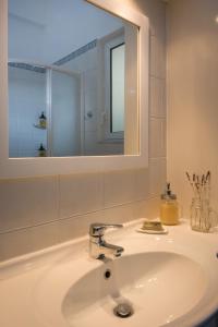 lavabo con espejo y lavabo en Straight to the Lake View Apartments, en Agios Nikolaos