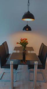 einen Esstisch mit einer Blumenvase darauf in der Unterkunft Modernes 2 Zimmer Appartment in Göttingen