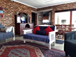 a bedroom with a bed with blue and red pillows at Beaufort 8 in Jeffreys Bay