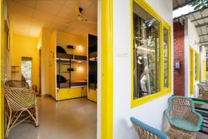 a hallway of a house with chairs and tables at The Hosteller Rishikesh, Tapovan in Rishīkesh