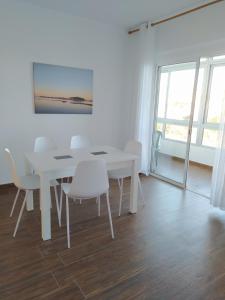 uma sala de jantar branca com uma mesa e cadeiras brancas em Ca la Nuri Pis 4 vistas al mar em Llançà