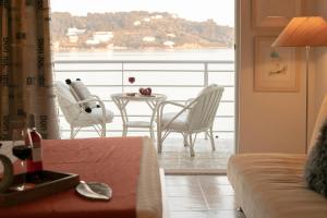 a living room with a table and chairs on a balcony at Casa Blue Marine, Philian Collection in Skiathos