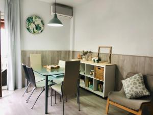 a dining room with a table and chairs and a book shelf at Apartamento Llimera Altea in Altea