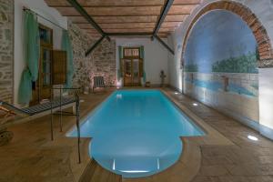 an indoor pool in a house with an archway at Villa De' Michelangioli in Castroncello
