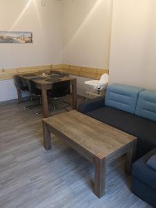 ein Wohnzimmer mit einem Tisch und einem blauen Sofa in der Unterkunft Apartament z Widokiem in Władysławowo