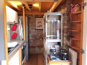 a kitchen in a tiny house with a stove at Duplex Swimming Cats in Saint-Hilaire-sur-Helpe