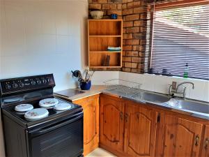 a kitchen with a stove and a sink at Beaufort 8 in Jeffreys Bay