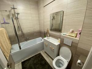 a bathroom with a tub and a toilet and a sink at Top View Apartment in Suceava