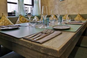 een tafel met glazen en borden en bestek erop bij amã Stays & Trails La Maison Fontainhas in Panaji