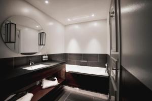 un bagno con vasca, lavandino e specchio di Hooks Herrgård a Hok