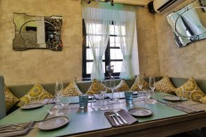 a table with plates and wine glasses on it at La Maison by Dia Hotels and Homes in Panaji