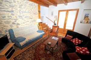 a living room with a bed and a stone wall at Appartement de 2 chambres avec balcon et wifi a La Grave in La Grave