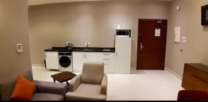 Il comprend un salon avec un canapé et une cuisine. dans l'établissement سيلين هوم الملقا, à Riyad