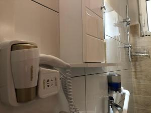 a phone on a wall in a bathroom at Lemon Tree Inn in Markopoulo +30 photos