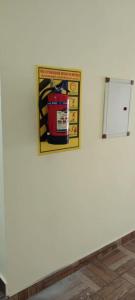 a picture of a fire extinguisher on a white wall at GIRI NANDHANA RESIDENCY in Yelagiri