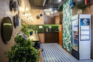 a kitchen with a refrigerator and some plants at Capsule Hotel InterQUBE Tretyakovskaya in Moscow