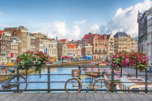 two bikes parked next to a river with buildings at Zee & Zo in Zandvoort