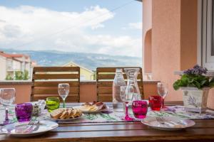 a table with plates of food and wine glasses at Apartment Lana in Šilo +28 photos