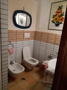 bagno con servizi igienici, lavandino e specchio di la casa di Mario a Itri