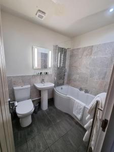 a bathroom with a toilet and a tub and a sink at Ye Olde Fighting Cocks in Arnside +26 photos