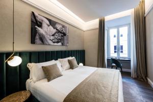 a bedroom with a large bed with a green headboard at Growel Exclusive Suites San Pietro in Rome