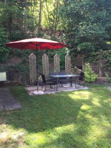 una mesa y sillas bajo una sombrilla en un patio en Ferienhaus Bussard en Gammelsbach