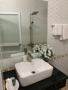 een badkamer met een witte wastafel en een spiegel bij hotel duclong2 in Hòn Một