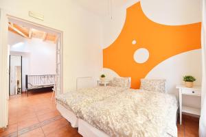 a bedroom with a bed with an orange wall at La Casa Mata Central in Málaga +21 photos