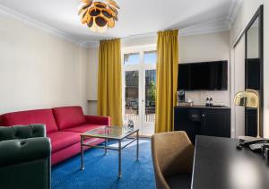 a living room with a red couch and a table at ProfilHotels Copenhagen Plaza in Copenhagen