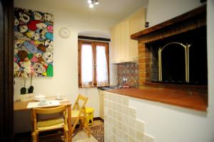 a kitchen with a fireplace and a table and chairs at Appartamento Tulipano Rosa in Spoleto