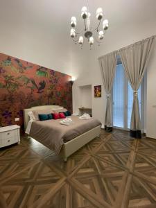 a bedroom with a large bed and a chandelier at Relais del Corso in Manfredonia