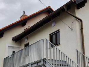 a white house with a staircase and a window at Holiday Home in Quiet Beautiful Area With Two Separate, Modern, Furnished Apartments in Deutsch-Wagram