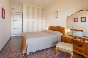 a bedroom with a bed and a mirror and a dresser at Metaxa Seafront Apartment in Perea