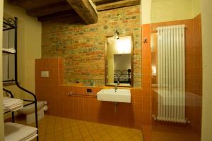 フィオレンツオーラ・ダルダにあるAgriturismo Arte Contadinaのレンガの壁、洗面台付きのバスルーム