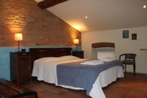 フィオレンツオーラ・ダルダにあるAgriturismo Arte Contadinaのレンガの壁、ベッド2台が備わるベッドルーム1室が備わります。