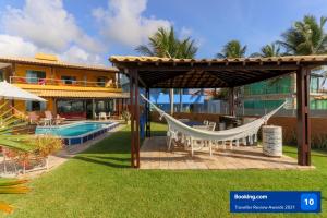 a hammock in the yard of a resort at Casa a beira mar com 4 suites e muito conforto in Porto De Galinhas
