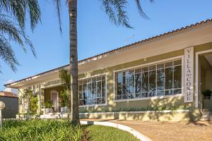 a house with a palm tree in front of it at Villa do Conde in Brotas