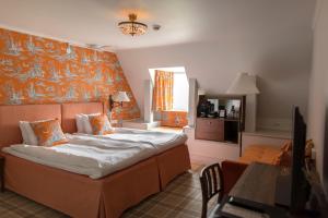 una camera da letto con un letto con una parete arancione di Hooks Herrgård a Hok