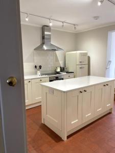a kitchen with a white counter and a refrigerator at The Old Carriage House in York