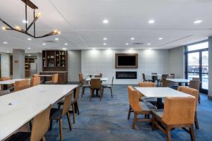 a dining room with tables and chairs and a tv at La Quinta Inn & Suites by Wyndham-Albany GA in Albany