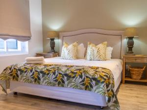 a bedroom with a large bed with a colorful blanket at River House in Plettenberg Bay