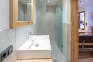 y baño con lavabo blanco y ducha. en Appartement Haus Sonntal en Fieberbrunn