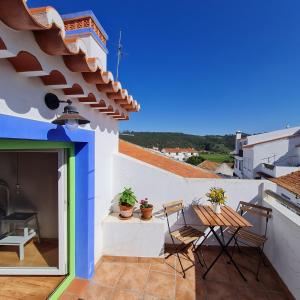 a patio with chairs and a table on a building at Alba Odeceixe - casa clara in Odeceixe