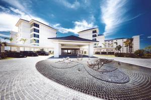 石垣岛全日空石垣岛洲际度假酒店的一座白色的大建筑,前面有一个钟 更多37张照片